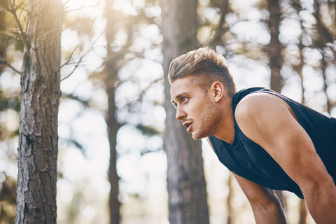 Young man pausing on an outdoor run. Exercise is an excellent habit for great skin
