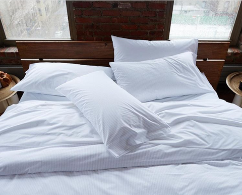 The Best Sleep Hacks for Peak Athletic Performance. A relaxing bed with white sheets and pillows