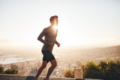 Man running outdoors with sun shining behind him