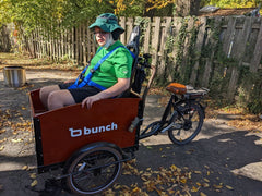 Adult in custom installed go kart seat in bunch bike