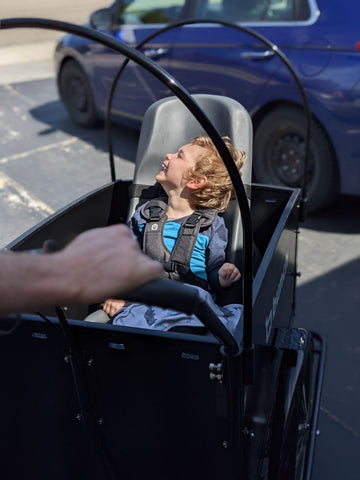 Child riding in special tomato car seat in bunch bike