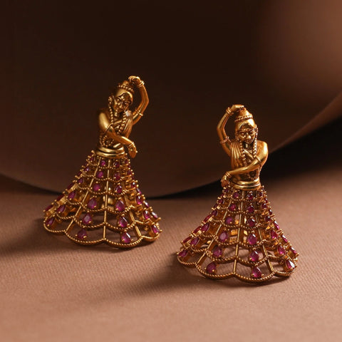 An image of Indian jhumkas with jaali work where the pattern of the jhumkas are dancing ladies.