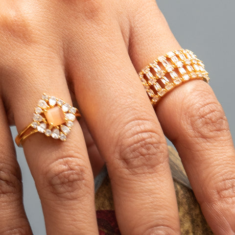 A picture of a woman's hand wearing different finger rings