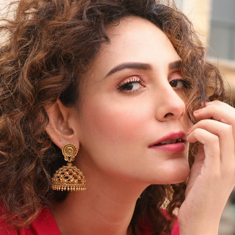 A picture of a woman showcasing a jhumka with floral motif