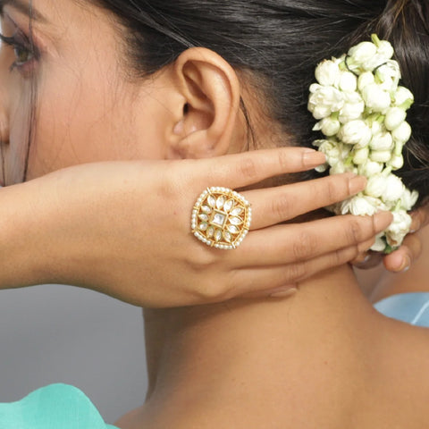 An image of a woman showcasing a kundan finger ring, crafted with kundan stones.