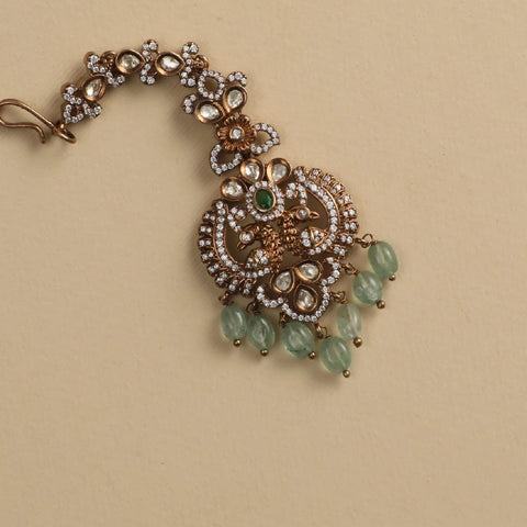 An image of an Indian maang tikka, crafted with gemstones and beads.