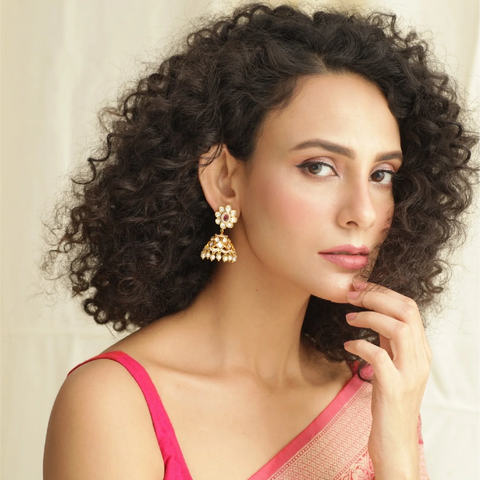 A close image of a woman wearing a pair of jhumka earrings