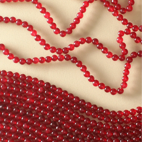 An image of a strand of red beads on a white background