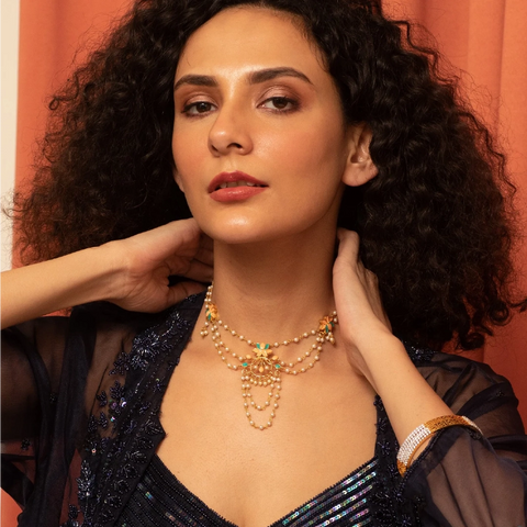 An image of a woman showcasing an enamel necklace.