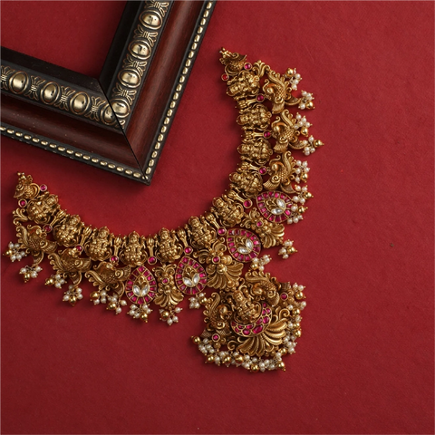 An image of an Indian antique necklace set on the red background