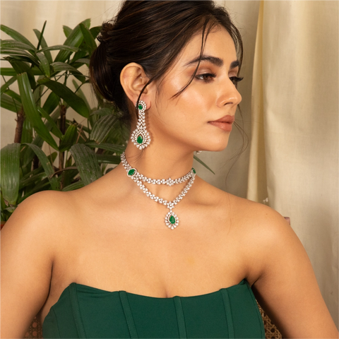 An image of a woman wearing green off shoulder dress with a layered necklace, crafted with cubic Zirconia