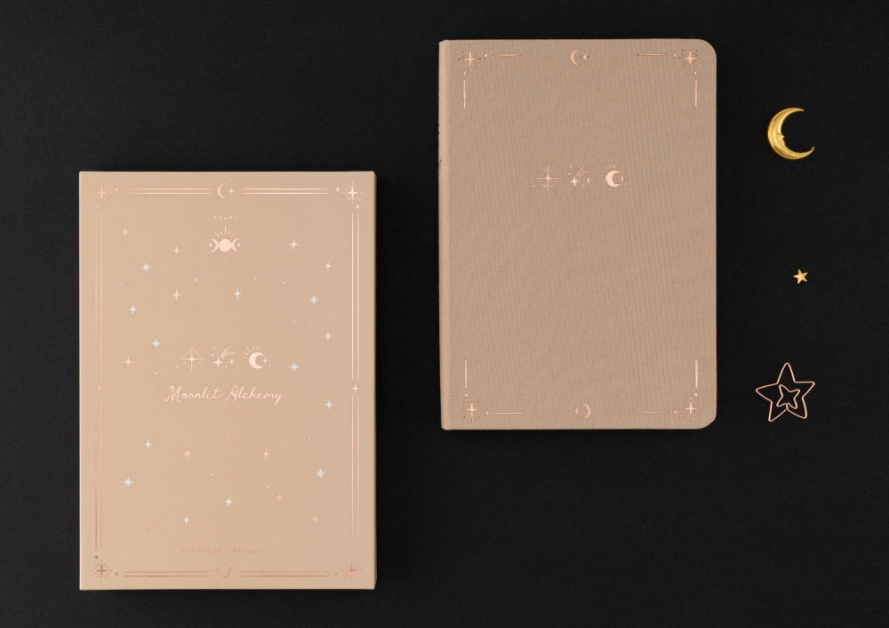 Flatlay of Tsuki Stardust Dawn Bullet Journal and Moonlit Alchemy gift box
