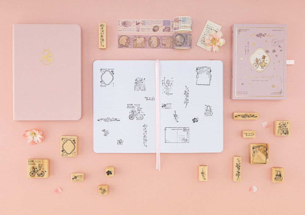Tsuki Love Lock collection including key bullet journal, washi tape set and stamp set with flowers in the background