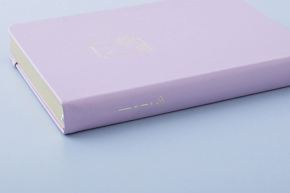 Close up of Tsuki Endless Summer Limited Edition Bullet Journal in Lilac Bloom on light blue background