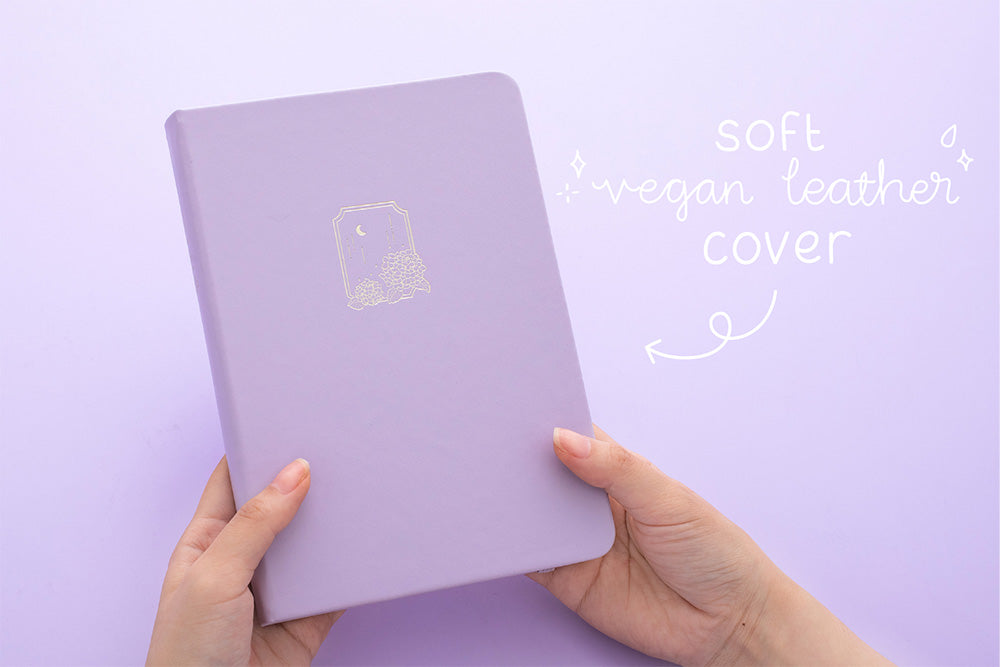 Tsuki Endless Summer Limited Edition Bullet Journal in Lilac Bloom with soft vegan leather cover held in hands in lilac background