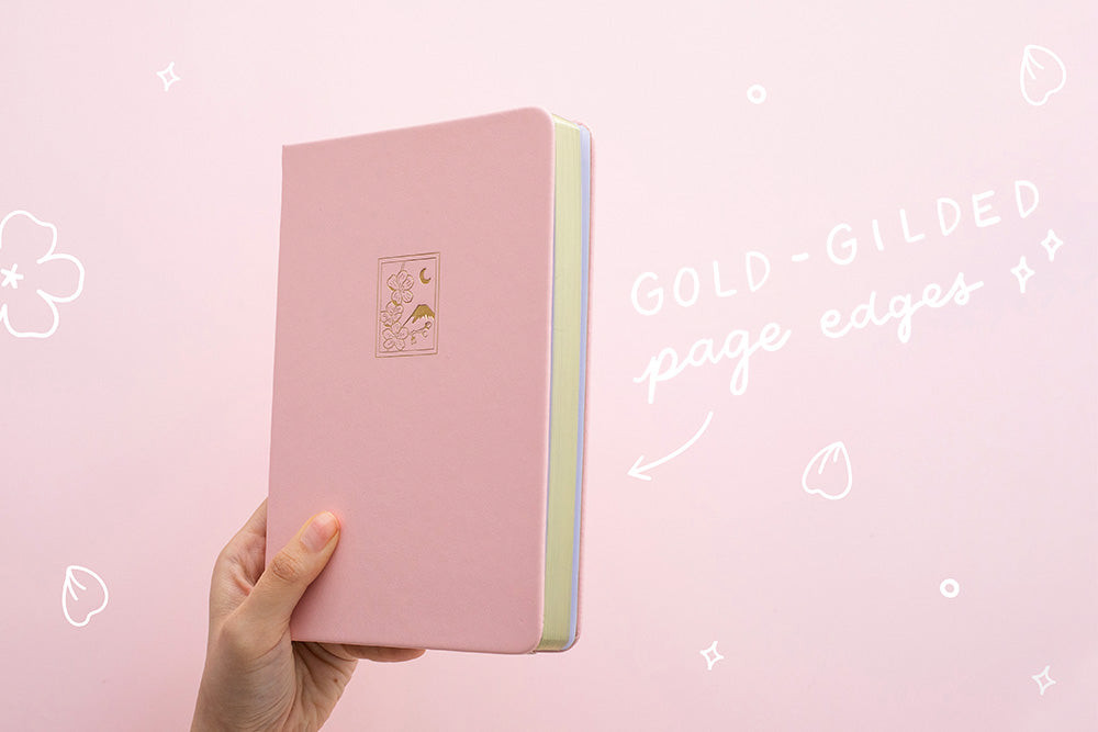 Petal pink bullet journal notebook cover and gold gilded page edges on a pink background