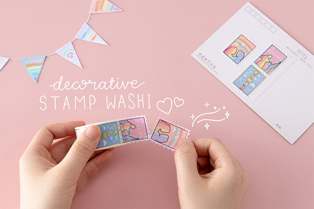 Tsuki Rainbow Pride Washi Tape with decorative stamps held in hands with postcard and bunting on light pink background
