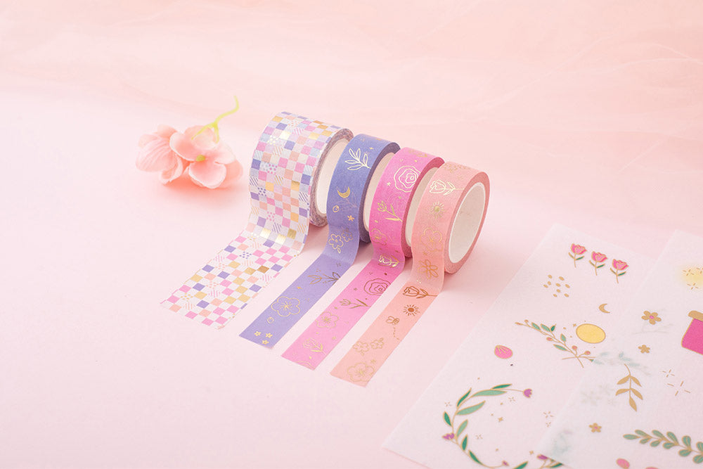 Tsuki Floral collection washi tapes rolled out and sticker sheets laid out on pink background