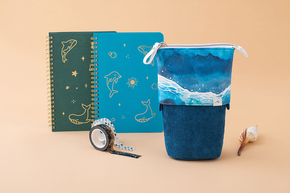 Tsuki Ocean Edition pop up standing pencil cases in Ocean Blue with Tsuki Ocean Washi Tape and aqua blue and moss green Limited Edition Tsuki Ocean Ring Bound notebooks with seashell in peach background