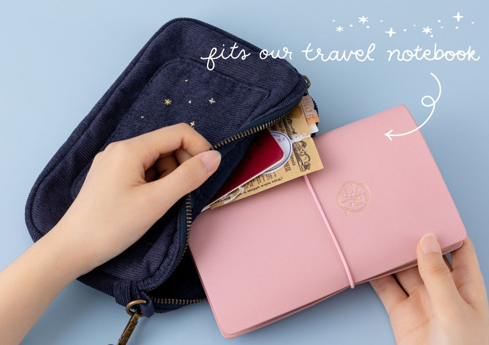 Tsuki ‘Cloud Dreamland’ Travel Pouch with Tsuki ‘Sakura Journey’ Limited Edition Travel Notebook, passport and tickets inside with writing that says “fits our travel notebook
