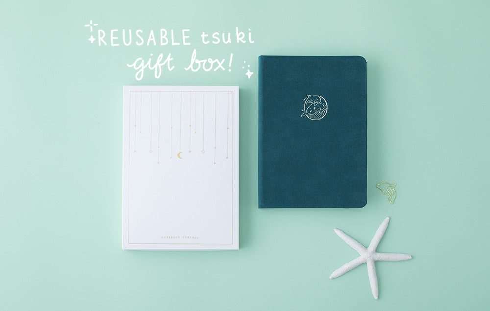 Tsuki sea green textured leather Dolphin Days notebook with eco-friendly gift box and starfish on green background