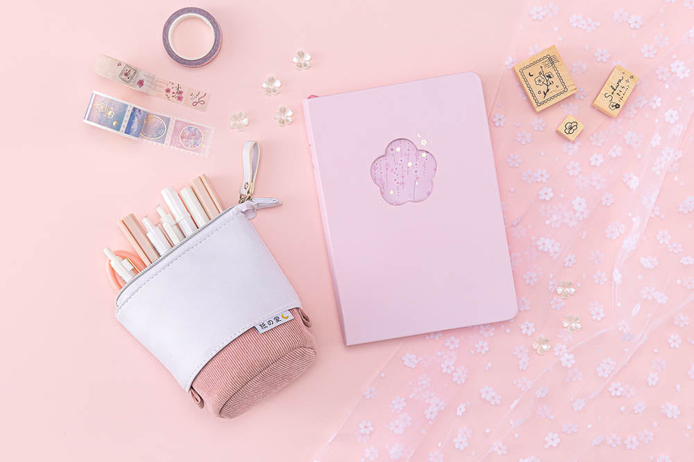 Tsuki Four Seasons: Spring Collector’s Edition 2022 Bullet Journal with Tsuki Pop-Up Pencil Case in sakura pink and Tsuki ‘Sakura Journey’ Washi Tapes and Tsuki ‘Sakura Journey’ Bullet Journal Stamps on floral netting with flowers on light pink background