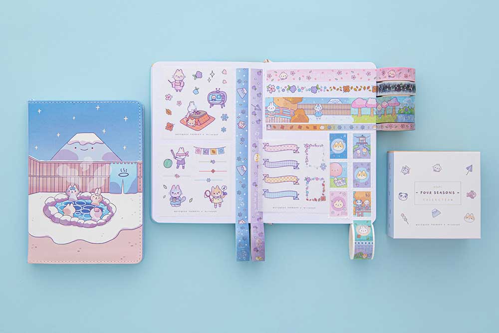 Tsuki ‘Four Seasons’ Washi Tape Set by Notebook Therapy x Milkkoyo rolled out on open bullet journal spread with Tsuki ‘Four Seasons: Winter Edition’ Bullet Journal on light blue background