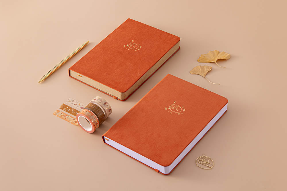 Tsuki ‘Kitsune’ Limited Edition Fox Bullet Journal with Tsuki ‘Kitsune’ Kraft Paper Limited Edition Fox Notebook and Tsuki ‘Maple Dreams’ Washi Tapes and autumn leaves and gold pen on beige background