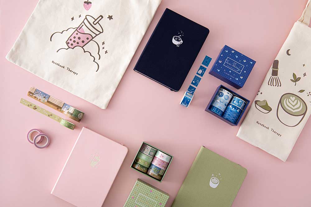 Tsuki ‘Matcha Matcha’ Tote Bag and Tsuki ‘Matcha Matcha’ Limited Edition Bullet Journal and Tsuki ‘Matcha Ichigo’ Washi Tape Set and Tsuki ‘Ichigo’ Boba Tote Bag and Tsuki ‘Ichigo’ Limited Edition Boba Bullet Journal and Tsuki ‘Cup of Galaxy’ Limited Edition Holographic Bullet Journal and Tsuki ‘Cup of Galaxy’ Washi Tape Set on light pink background