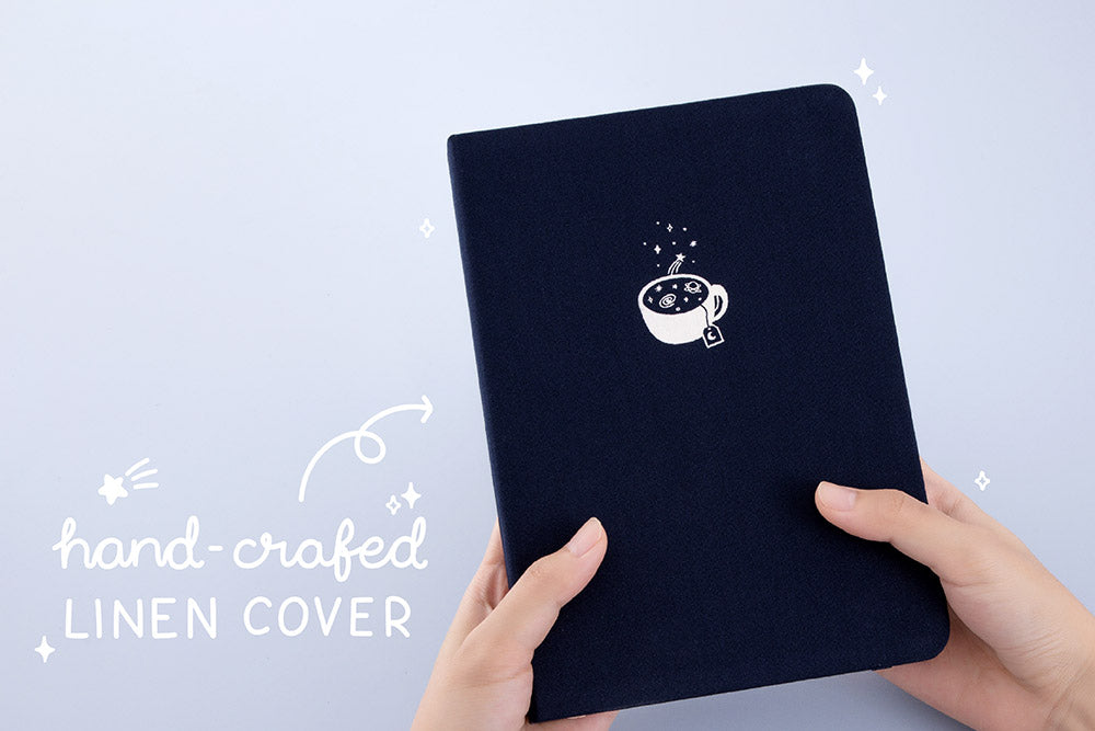 Tsuki ‘Cup of Galaxy’ Limited Edition Holographic Bullet Journal with handcrafted linen cover held in hands in light blue background