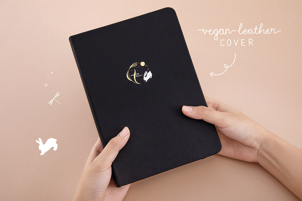 Tsuki ‘Moonlit Wish’ Limited Edition Bullet Journal with vegan leather cover held in hands in light brown background