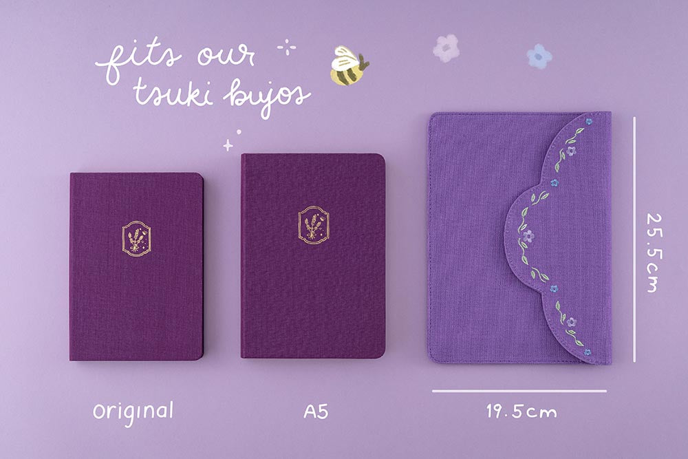 Flatlay showing original and A5 bullet journals fitting in notebook pouch on purple background