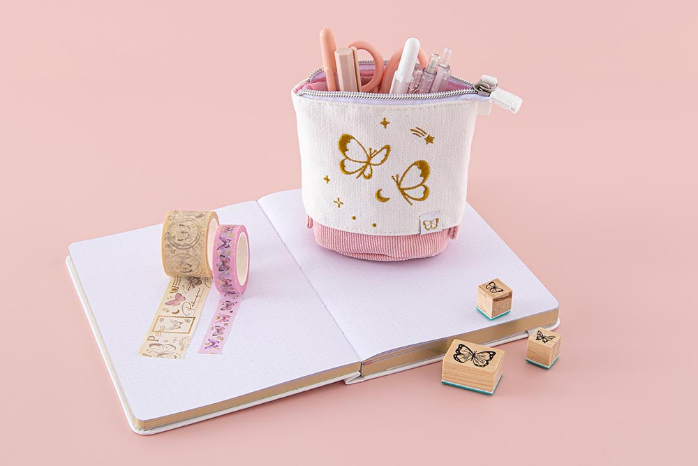 Tsuki ‘Flutter + Dream’ Pop-Up Pencil Case by Notebook Therapy x Pelinkan in pastel pink with open Tsuki Cloud White ‘Flutter + Dream’ Limited Edition Bullet Journal by Notebook Therapy x Pelinkan and Tsuki ‘Flutter + Dream’ Bullet Journal Stamps by Notebook Therapy x Pelinkan in pastel pink background