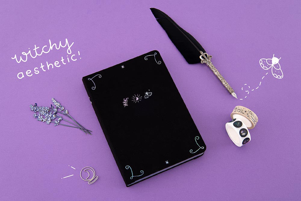 Tsuki ‘Moonlit Spell’ Limited Edition Holographic Bullet Journal with witchy aesthetic and free bookmark gift with Tsuki ‘Moonlit Spell’ Washi Tapes with black feather quill and lavender sprigs on purple background