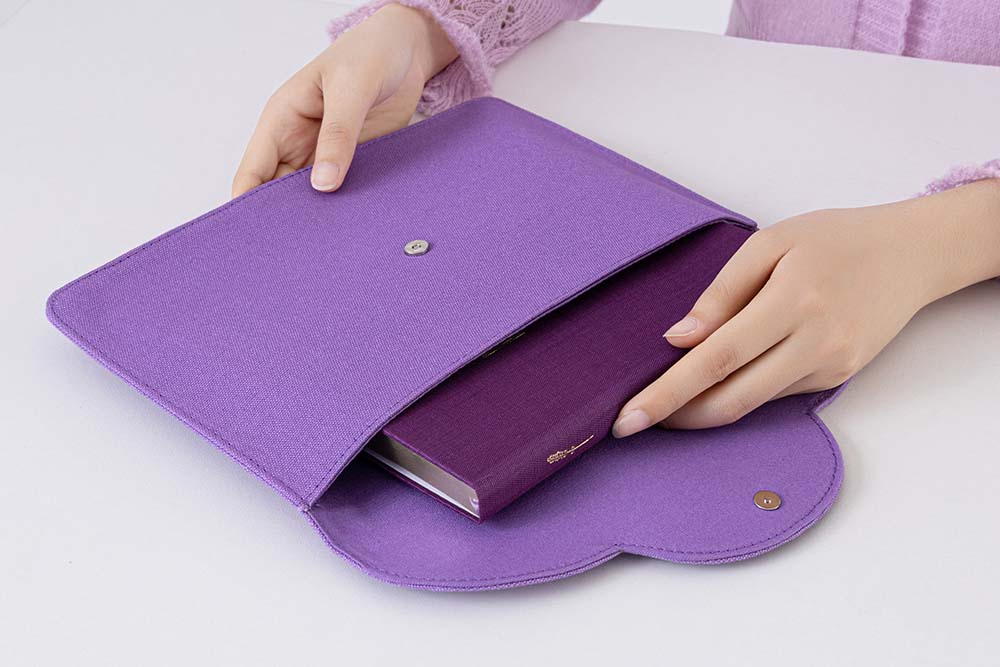 Hand putting a notebook inside the notebook pouch