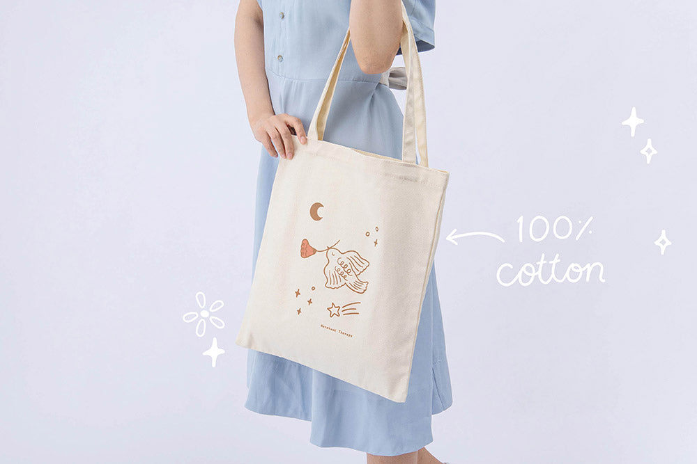 100% cotton Tsuki ‘Moonflower’ Limited Edition Tote Bag held in model’s hands in light blue background