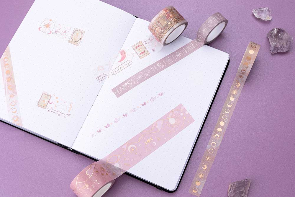 Tsuki ‘Moonlit Blush’ Washi Tape Set rolled out on open bullet journal page with amethyst stones on purple background