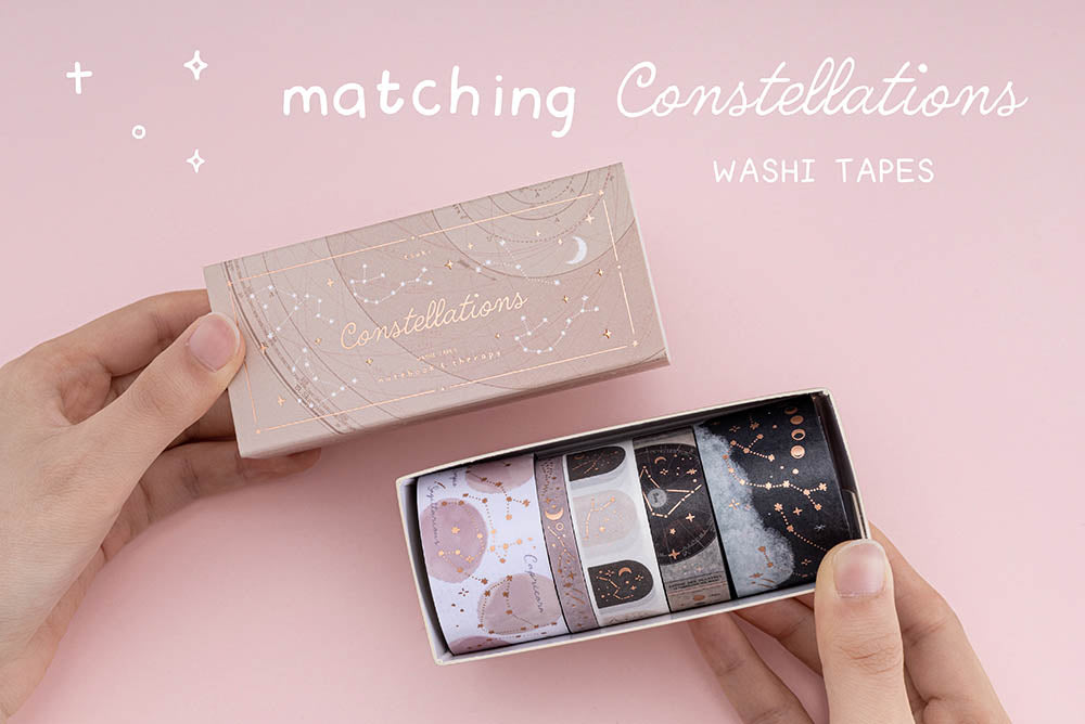 Hands holding tsuki constellations washi set open box with words “matching constellation washi tapes” written in white