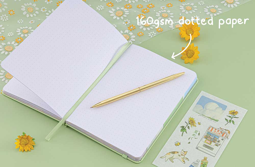 Opened Tsuki Four Seasons Summer Collectors Edition 2022 sage bullet journal notebook with gold pen on top and white text “160gsm dotted paper”