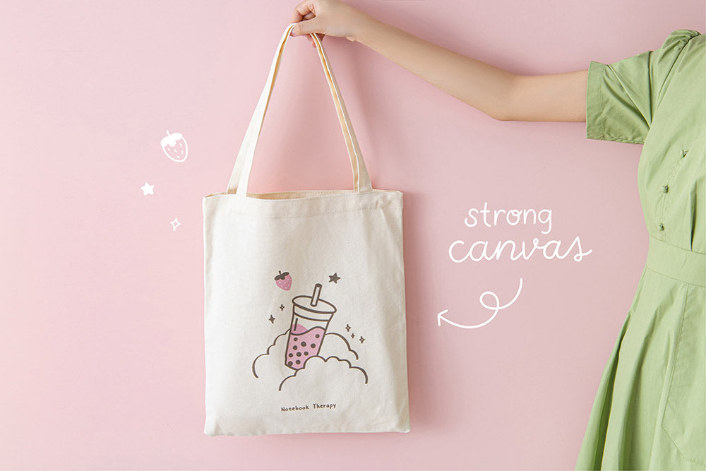 Tsuki ‘Ichigo’ Boba Tote Bag with strong canvas held in hands in light pink background