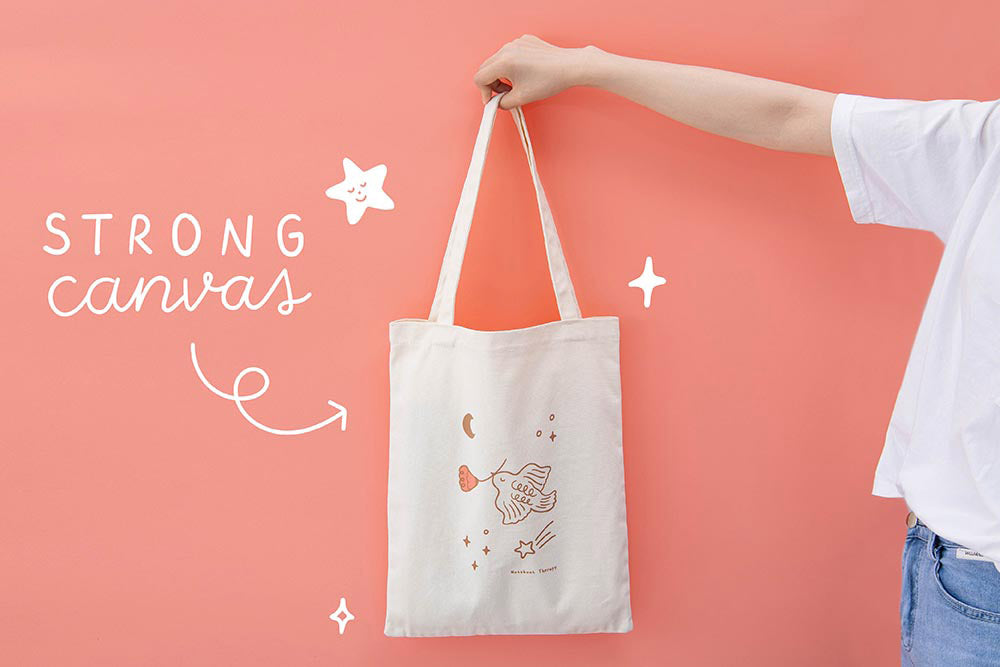 Strong canvas Tsuki ‘Moonflower’ Limited Edition Tote Bag held held in hands in coral pink background