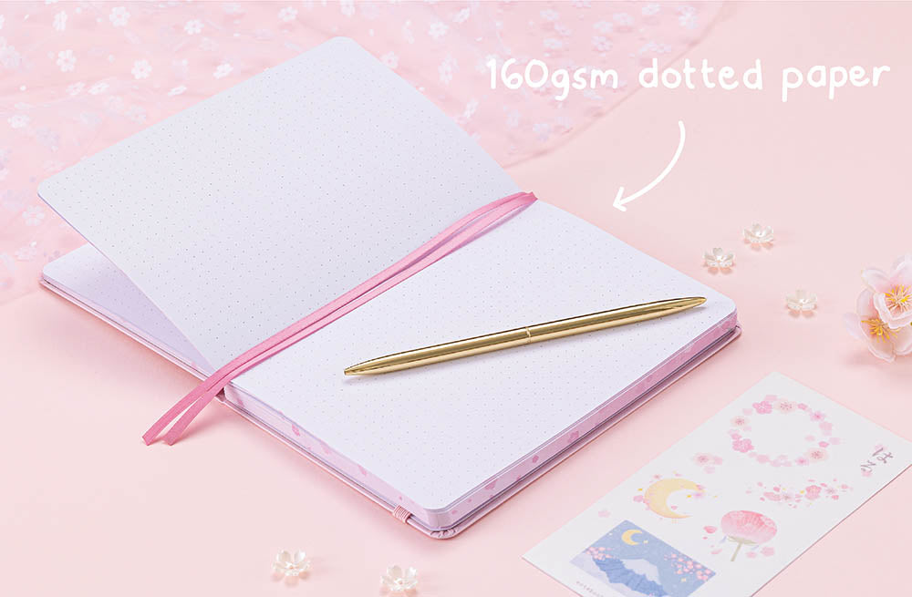 Open Tsuki Four Seasons: Spring Collector’s Edition 2022 Bullet Journal with 160GSM white dotted paper with gold pen and flowers near netting on light pink background