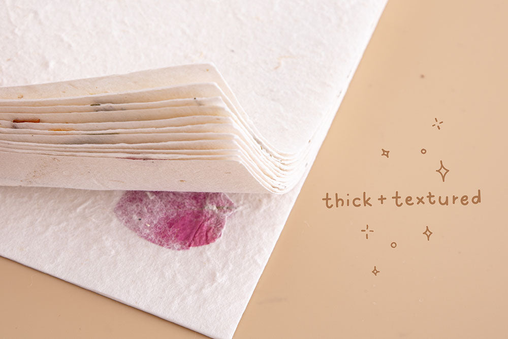 Close up of Tsuki Handmade Petal Papers corners with thick texture on beige background