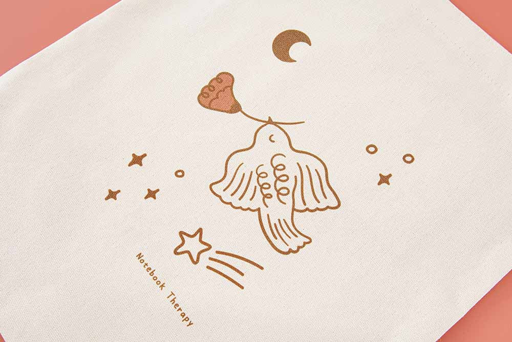 Close up of Suzume bird art design of Tsuki ‘Moonflower’ Limited Edition Tote Bag on coral pink background