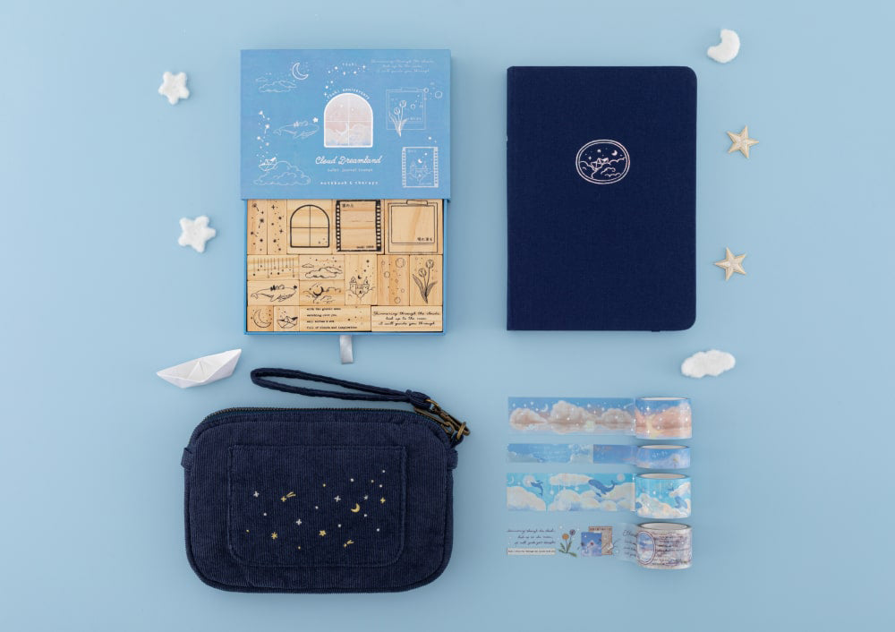 Flatlay of Dream Sailing notebook, Cloud Dreamland stamps, travel pouch and washi tapes