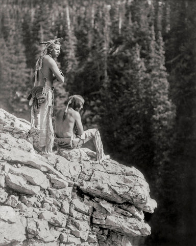 Photo of Two Native Americans Sitting on a Rock, overlooking a Forest