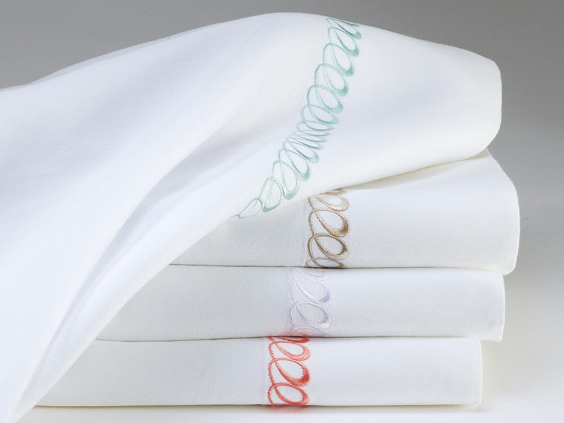 White sheets with playful looped embroidery in fun colors