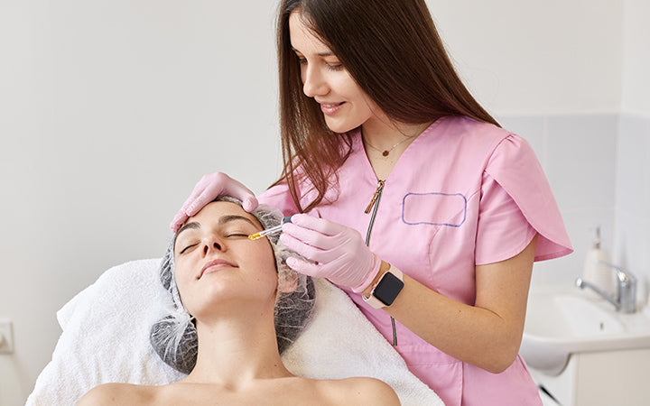 Cosmetologist makes beauty treatment for female  in beauty salon