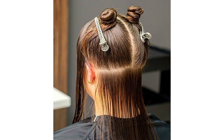 Divided women's hair into sections with clips
