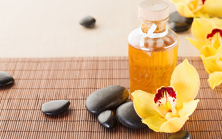 Essential oil, massage stones and orchid flowers